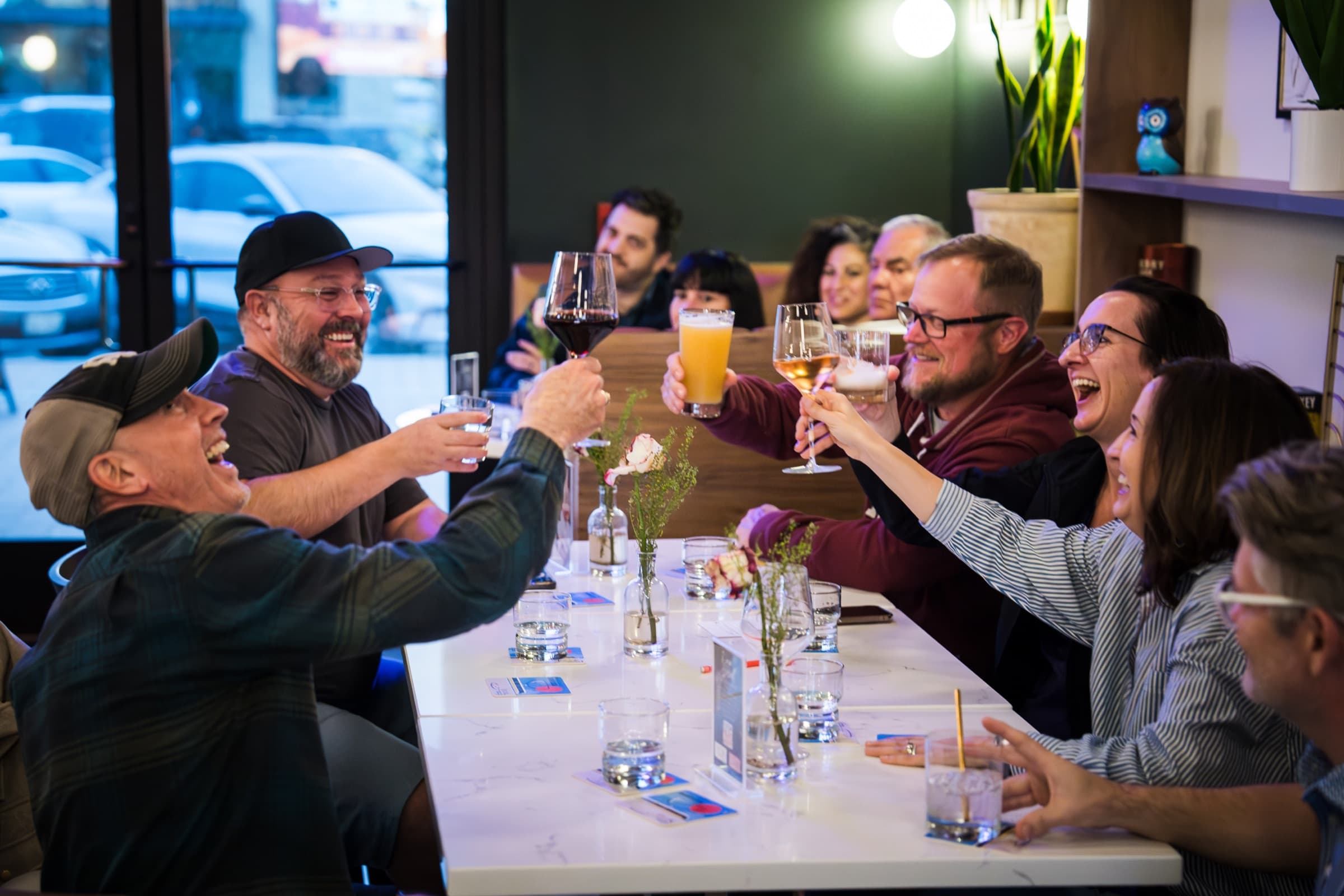 A group raising glasses around a table during a private gathering at Locals